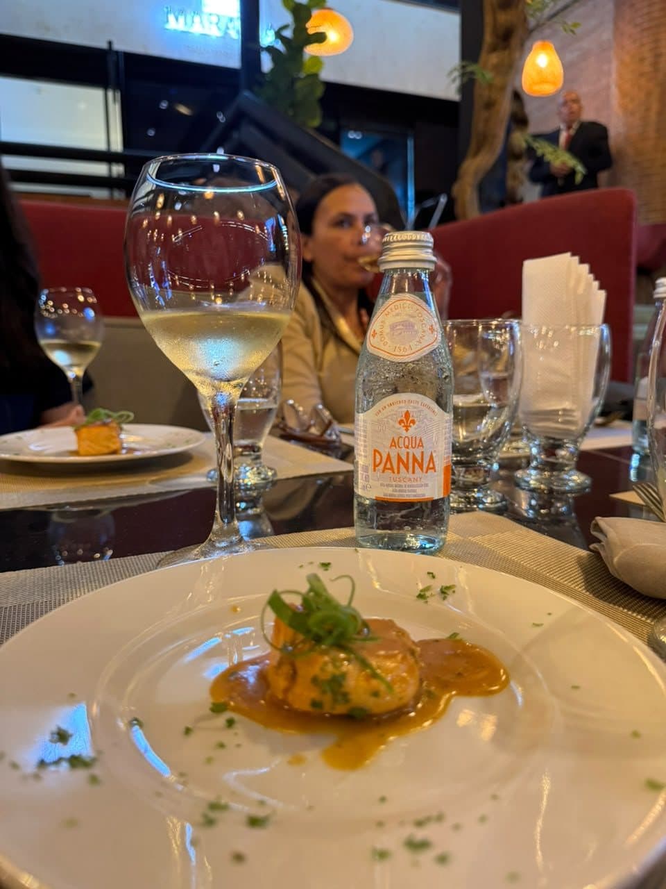 Plato de la cata con copa de vino blanco y agua Acqua Panna