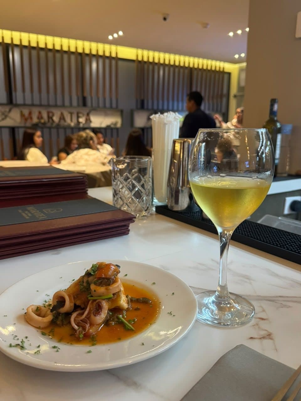 Plato de calamares maridado con una copa de vino blanco