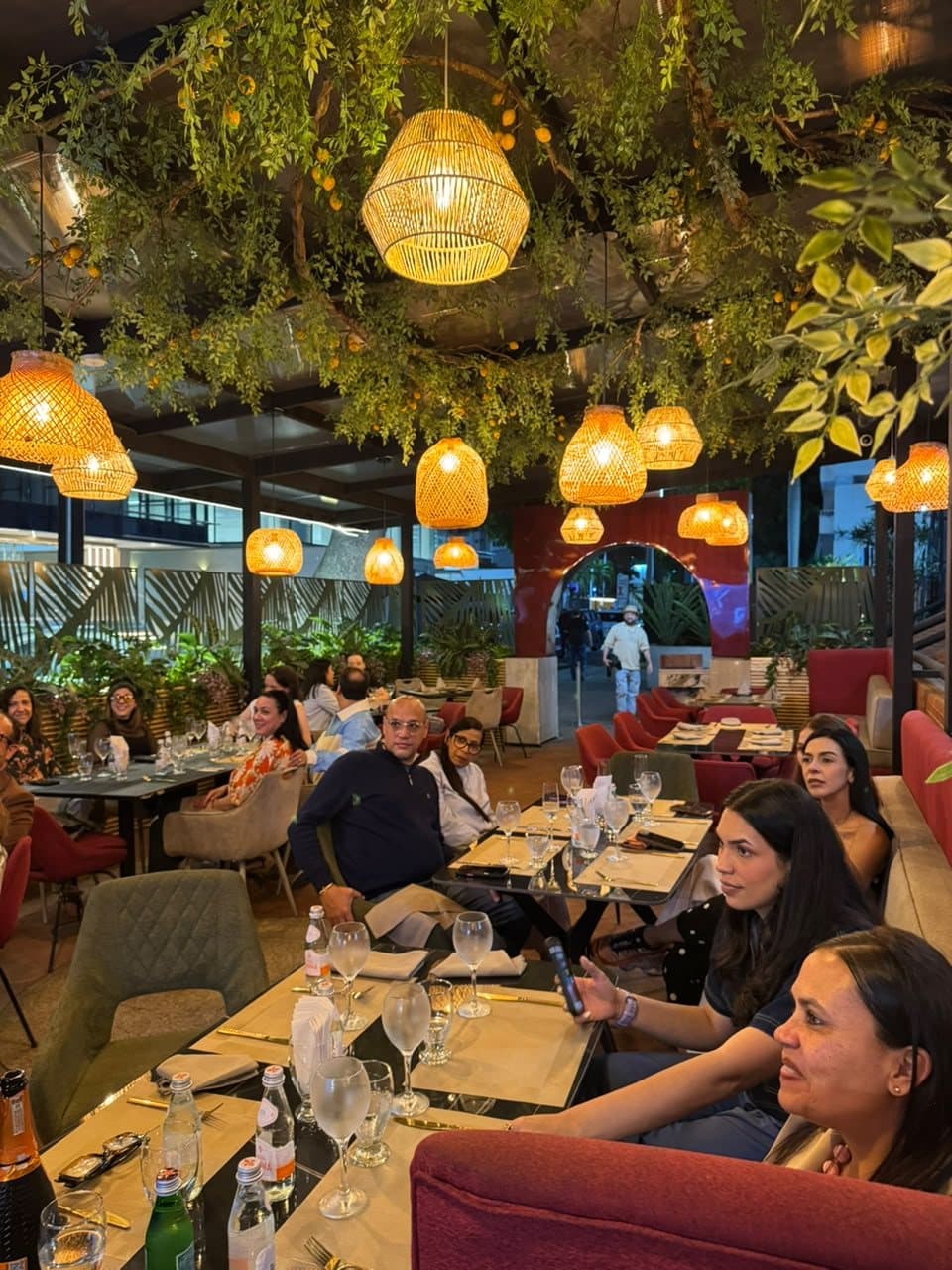 Terraza de Maratea llena de invitados bajo lámparas de mimbre